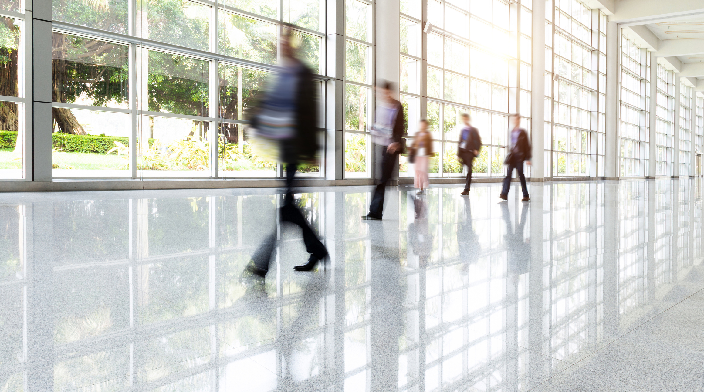 Group Of Business People Walking In Glass Building